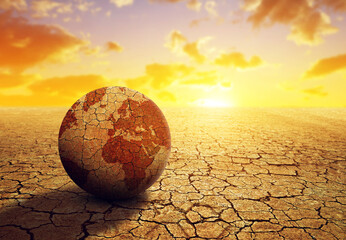 Parched planet earth in the dry landscape with cracked soil at sunset. Global warming or change...