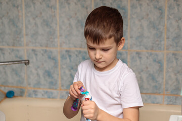 a boy of six is brushing his teeth in the bathroom. close-up portrait
