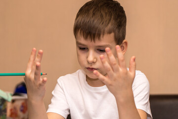 a six-year-old boy solves a math example with his fingers. close-up