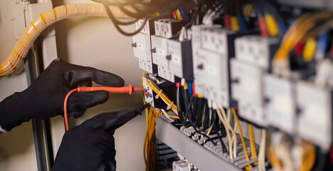 Electrician engineer work tester measuring voltage and current of power electric line in electical...