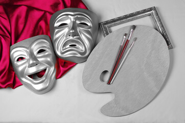 Comedy and tragedy masks with purple drapery, art palette and brushes on a light background....