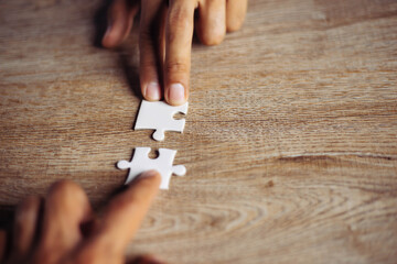Closeup hand of man connecting jigsaw puzzle with sunlight effect, Business solutions, success and...