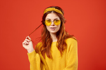 pretty emotional woman holding her hair Yellow sweater fashion red background