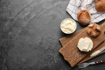 Bun with tasty cream cheese on dark background