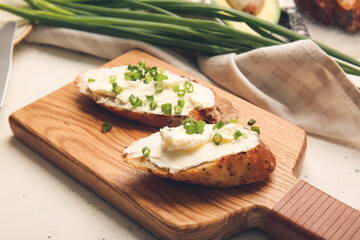 Bread with tasty cream cheese on light background