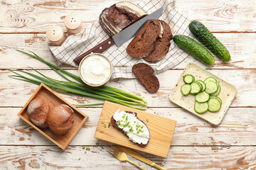 Bread with tasty cream cheese and green onion on wooden background