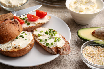 Sandwiches with tasty cream cheese on light background