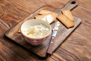 Crispbread with tasty cream cheese on wooden background