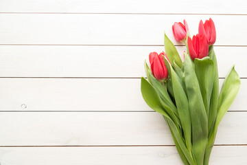 Bunch of spring tulips over white wooden background