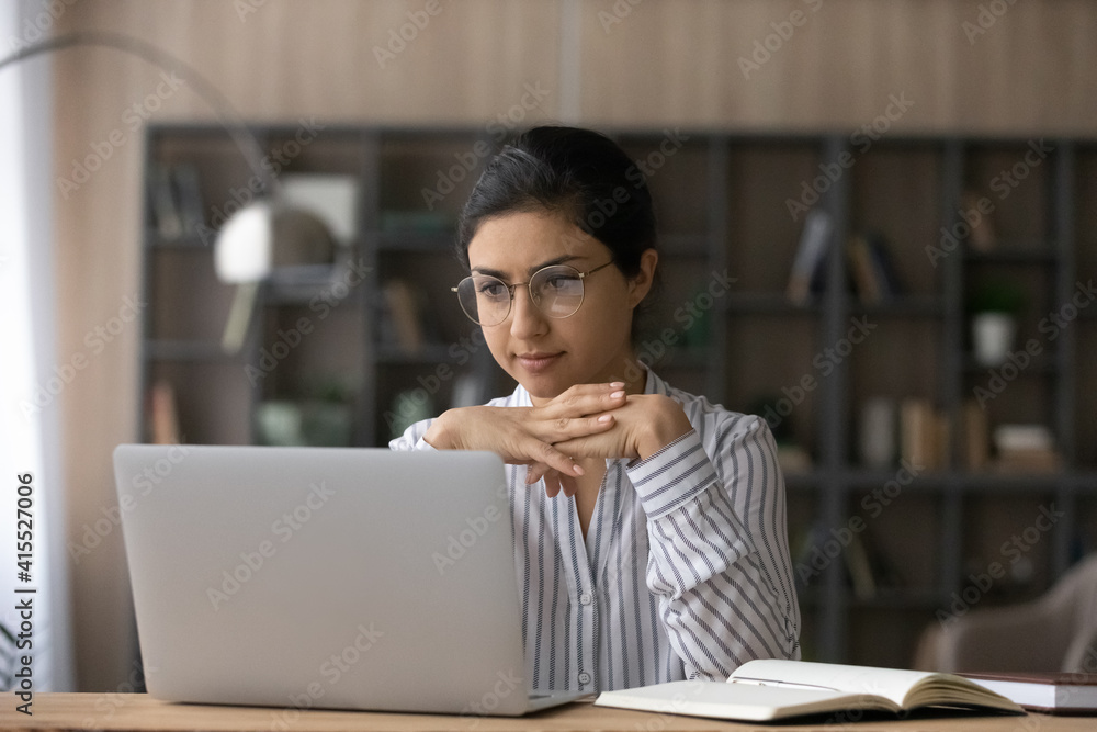 Canvas Prints pensive millennial indian woman in glasses look at laptop screen study distant from home. focused yo