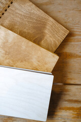 Notebooks with a wooden cover lie on the table