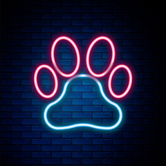 Glowing neon line Paw print icon isolated on brick wall background. Dog or cat paw print. Animal track. Colorful outline concept. Vector.