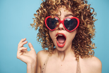 Emotional woman curly hair wide open mouth background blue red heart glasses brigh