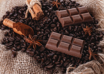 chocolate, coffee beans, anise on wooden background