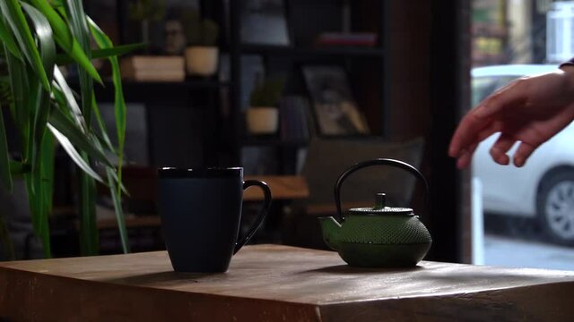 Cinematic Slow Motion Pouring Herbal Tea in Navy Blue Mug from Green Tea Pot