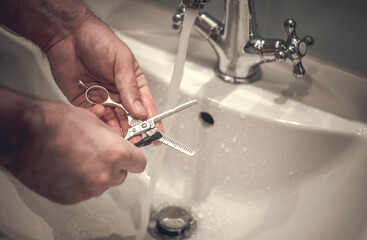 Washing under running water of hairdressing scissors for milling