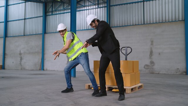Funny factory workers dance in the factory . Happy people at work .