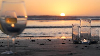 Candle flame light in glass, romantic beach date by California ocean waves, summer sea water. Candlelight. Wineglass, wine glass on sand. Cozy lounge, sunset sun reflection. Seamless loop cinemagraph