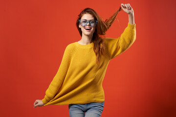 cheerful woman yellow sweater glasses fashion clothes studio red background