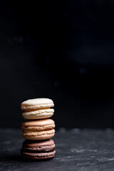 Fototapeta na wymiar A group of dark mood french macaroons cookies in beige and brown