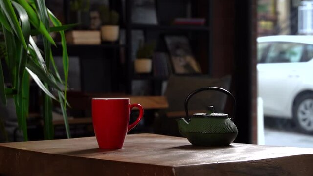 Cinematic Slow Motion Pouring Herbal Tea in Red Mug from Green Tea Pot
