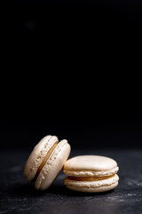 A group of dark mood french macaroons cookies in beige and brown