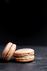 A group of dark mood french macaroons cookies in beige and brown