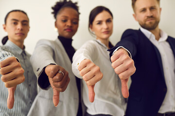 Group of young diverse people giving thumbs down, hands in closeup. Multiracial corporate HR...