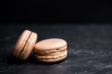 A group of dark mood french macaroons cookies in beige and brown