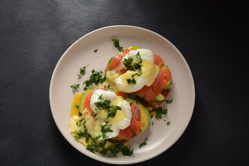 Eggs Benedict with smoked salmon, avocado slices and hollandaise sauce