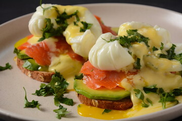 Eggs Benedict with smoked salmon, avocado slices and hollandaise sauce