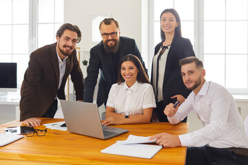 Obraz premium Group portrait of happy smiling business people near laptop in business center office.