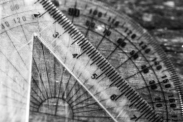 Monochrome image, mathematical rulers on aged weathered pine wood boards close up macro shot for background.