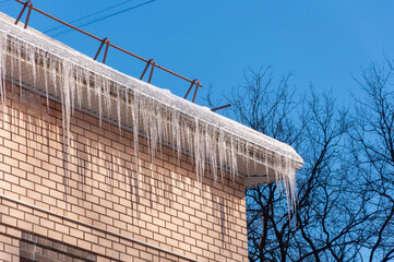 Roof Of The House With Snow And Icicles Overhanging