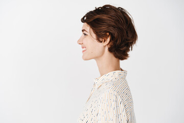 Side view of beautiful young woman with clean healthy skin, natural look without makeup, looking...