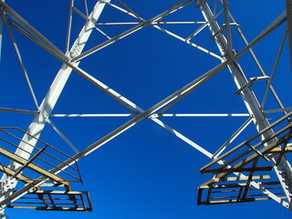 朝日の当たる送電鉄塔の鉄骨と青空