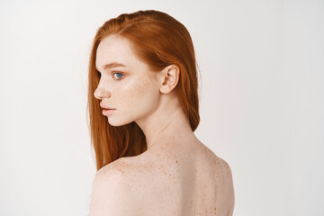 Haircare and skincare concept. Rear view of redhead woman back, turn head and looking left dreamy....