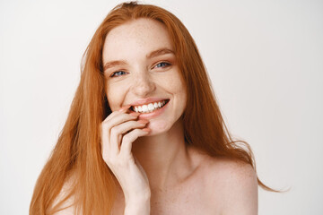 Skin and haircare. Beautiful smiling woman with long natural red hair and white teeth looking happy...