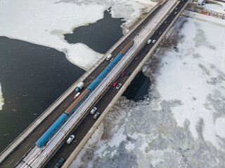 The Kiev metro train travels across the bridge through the Dnieper river. Aerial drone view. Winter sunny morning.