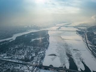 Light pillar from the sun over the Dnieper river in Kiev. Aerial drone view. Winter sunny morning.