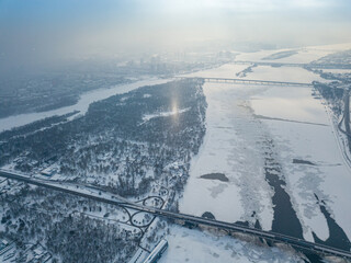 Light pillar from the sun over the Dnieper river in Kiev. Aerial drone view. Winter sunny morning.