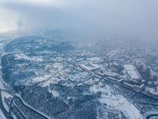 Fototapeta na wymiar Snow-covered Kiev-Pechersk Lavra in a blizzard. Aerial drone view. Snowy winter morning, blizzard. Black cloud over the city.
