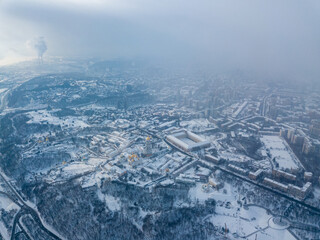 Snow-covered Kiev-Pechersk Lavra in a blizzard. Aerial drone view. Snowy winter morning, blizzard. Black cloud over the city.