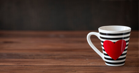 Stripy black and white Cup With red heart on wooden background. Valentine's Day Cup. Love Concept