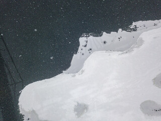 Ice edge on the river in a blizzard. Aerial drone view. Snowy winter morning, blizzard.