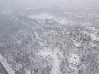 Snowy Kiev in a snowstorm, blizzard. Aerial drone view. Winter cloudy morning.