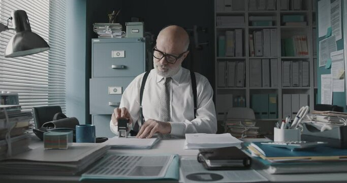Office worker stamping a pile of paperwork