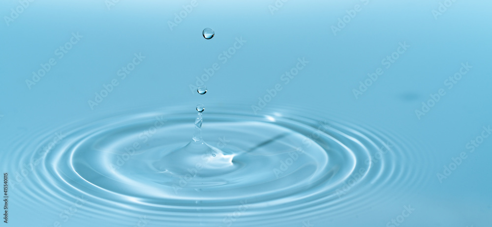 Wall mural drop of water drop to the surface. waves on the surface of the water from a collision