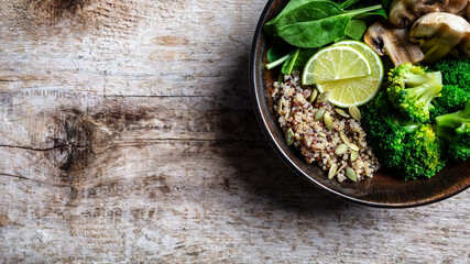 Diet salad made from fresh vegetables broccoli, mushrooms, spinach and quinoa in a bowl. Delicious breakfast or snack, Clean eating, dieting, vegan food concept. top view