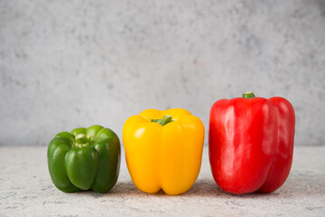 Fresh juicy bell peppers on a gray background